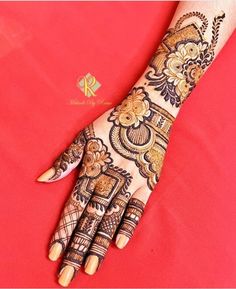 a woman's hand is decorated with hennap and gold designs on it