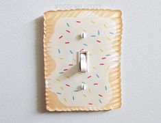 a decorative light switch plate with sprinkles on it is mounted to the wall