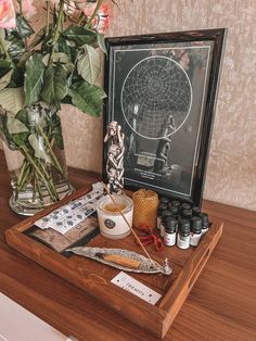 a wooden table topped with vases filled with flowers and other items on top of it