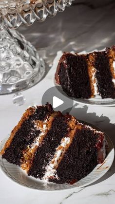 two slices of chocolate cake sitting on top of white plates next to a glass dish