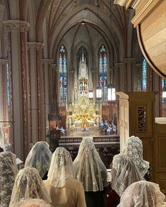 several people wearing veils in front of a church alter