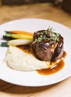 a white plate topped with meat and mashed potatoes