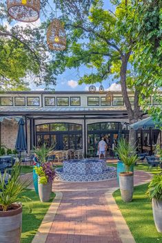 an outdoor patio area with potted plants and tables in the background, surrounded by trees