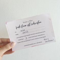 a person holding up a fake flower gift certificate