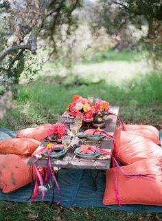 a picnic table set up with pillows and plates