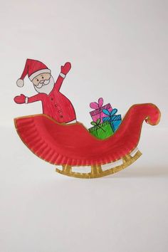 a paper plate santa clause riding on a sleigh with presents in the back