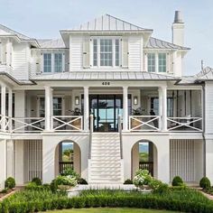 a large white house with lots of windows and balconies on the second floor