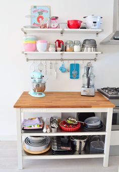 a kitchen island with lots of plates and bowls on it's shelf above the stove