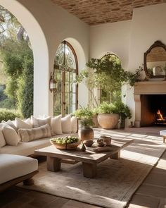 a living room filled with furniture and a fire place in the middle of an open floor plan