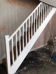 a white staircase being painted in an empty room