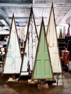 three wooden surfboards sitting on top of each other in front of a white door