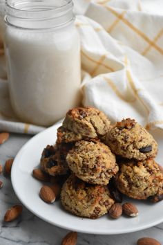 cookies and almonds on a plate next to a glass of milk