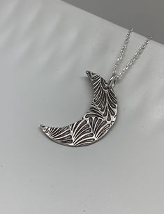 This unique silver moon necklace has been entirely handmade using .999 fine silver. It has been cut from fine silver precious metal clay, textured, fired and oxidized. The pendant hangs from a sterling silver diamond cut cable chain. This fine silver pendant features an embossed feathery leaf print pattern and hangs 1 1/4 from top of ring to bottom of the moon shape. Pendant size: approximately 1 x 3/4 inches Chain length: adjustable at 16 and 18 inches can also be customized to whatever length Silver Moon Necklace, Moon Necklace Silver, Leaf Print Pattern, Silver Clay, Precious Metal Clay, Moon Shape, Silver Jewels, Leaf Jewelry, Bohemian Necklace