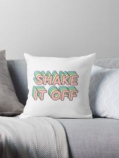 a throw pillow with the words shake it off in pink, blue and green colors