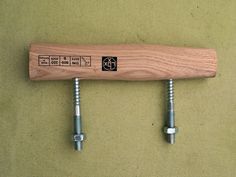 two screws are attached to a wooden baseball bat