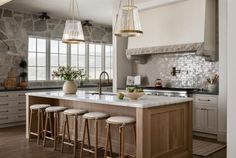 a kitchen island with four stools in front of it and an open window to the outside