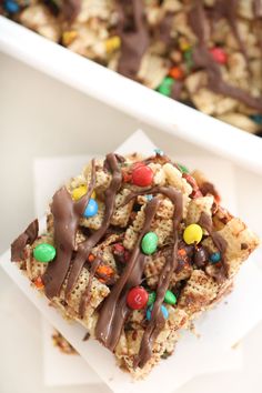 a white plate topped with cereal bars covered in chocolate and m & m candies