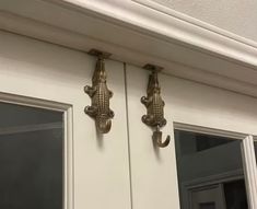 two metal gargons are mounted on the side of a building's door