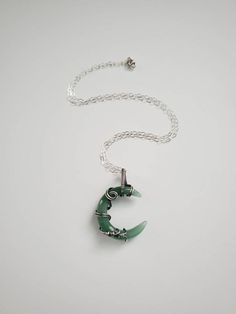 "This beautiful crescent moon shaped Green Aventurine stone is wrapped inside Sterling silver wire. Liver of sulphur has been used to give the silver an antique look, and it's sealed with Renaissance Wax to avoid tarnishing. The necklace has been made at 18\" on a Sterling silver chain, but length can be adjusted to fit your personal taste. The pendant hangs 1.5\" from chain. Finished with a lobster clasp. All my jewelry is handmade, and made with patience, care and love. In the unlikely event t Spiritual Crescent Wire Wrapped Necklaces, Silver Crescent Crystal Necklaces For Jewelry Making, Handmade Silver Crescent Crystal Necklace, Wire Wrapped Crescent Metal Jewelry, Green Crescent Moon Charm Jewelry, Handmade Green Crescent Jewelry, Handmade Silver Jade Crystal Necklaces, Handmade Silver Jade Crystal Necklace, Green Aventurine Jewelry