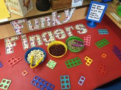 a table topped with lots of different types of toys next to a sign that says funky fingers