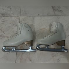 a pair of ice skates sitting on top of a marble floor next to each other