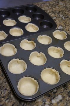 an uncooked muffin pan with twelve cupcakes in it on a granite countertop