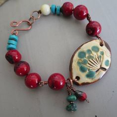 Nothing better than Red coral and Turquoise to enhance this beautiful 35x25mm artisan ceramique link. With the lovely turquoise and red charms, the antique copper is the perfect color. I made the antique copper hook myself and I've handknotted the beads with a nylon cord for more strenght and flexibility.   The bracelet will fit a 6'' to 6 1/2'' wrist. I use only top quality beads and lead/chromium free components. In attempt to reduce the environmental impact, I don't include a packing slip in the orders. You can print your own copy from your purchased orders on Etsy. Thank you for your visit! Please come again! 1121 Earthy Red Handmade Jewelry, Earthy Red Jewelry For Gifts, Rustic Red Jewelry For Gifts, Rustic Red Jewelry As A Gift, Red Charm, Packing Slip, Charms Bracelet, Copper Turquoise, Dec 12