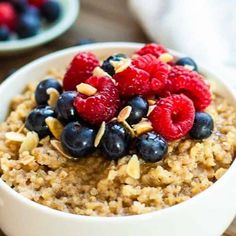 a bowl filled with oatmeal topped with berries and nuts