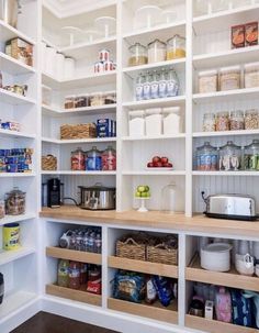 an organized pantry with white shelving and wooden shelves