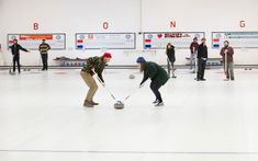 several people are playing curling in an indoor rink