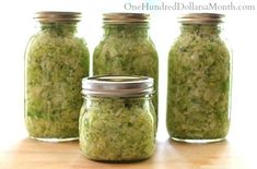 three jars filled with green food sitting on top of a wooden table