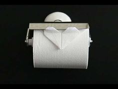 a roll of toilet paper with an origami bow on it is sitting in front of a black background