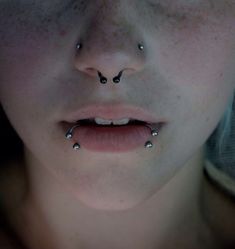 a woman with piercings on her nose looking at the camera