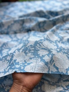 a person's hand is holding onto a blue and white comforter