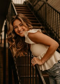 a beautiful young woman leaning against a railing