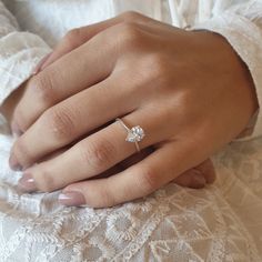 a woman's hand with a diamond ring on it