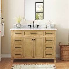 a bathroom vanity with a large mirror above it and a rug in front of it