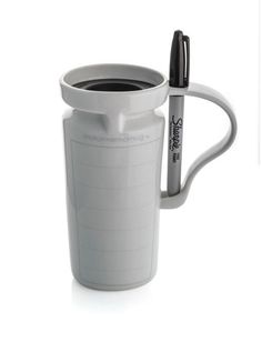 a white cup with a black pen in it