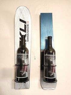 two wine bottles are attached to the back of a snowboard that is mounted on a wall