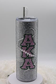 a silver can with pink and black designs on it