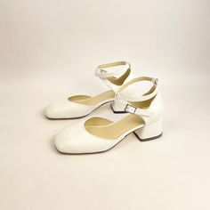 Elegance meets simplicity with these beautiful white block-heeled Mary Jane shoes, crafted with care to bring you a timeless and versatile addition to your footwear collection. Featuring a classic single ankle strap for a secure fit and a stylish square toe, these shoes are perfect for any occasion - from casual days out to formal events. The low block heel provides just the right amount of height without compromising comfort, making these shoes a practical yet fashionable choice. Each pair is h White Court Shoes With Heel Strap, Medium Width, White Court Shoes With Heel Strap And Medium Width, White Court Shoes With Heel Strap, White Low Heel Court Shoes For Spring, White Block Heel Mary Jane Heels, White Mary Jane Heels With Block Heel, White Mary Jane Block Heels, White Closed Toe Court Shoes, White Court Shoes With Round Toe And Medium Width