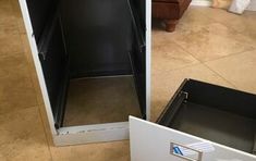 an open refrigerator sitting on top of a tiled floor next to a white cabinet with its door open