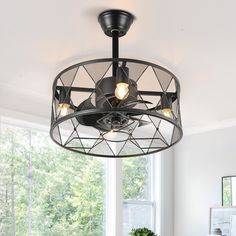 a ceiling fan that is hanging from the ceiling in a room with white walls and windows