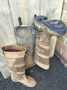 an old pair of boots sitting next to a wooden door with a hook on it