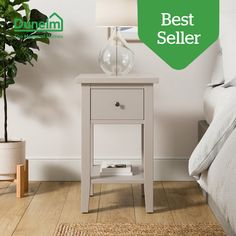 a white bedside table with a green sign over it that says best seller next to a bed