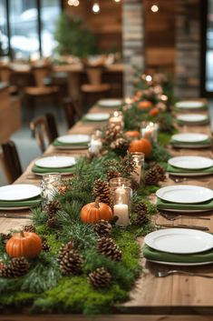 the table is set with pine cones, candles and greenery for an elegant look