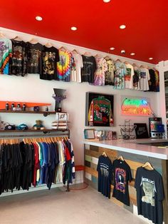 a clothing store with t - shirts hanging on the wall and other items on display