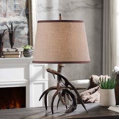 a table lamp with antlers on it in front of a fireplace