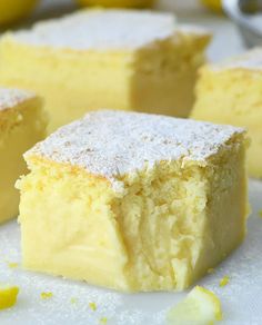 two pieces of lemon cake sitting on top of a white plate next to sliced lemons