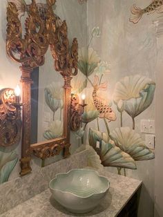 a bathroom with a sink, mirror and decorative wallpaper